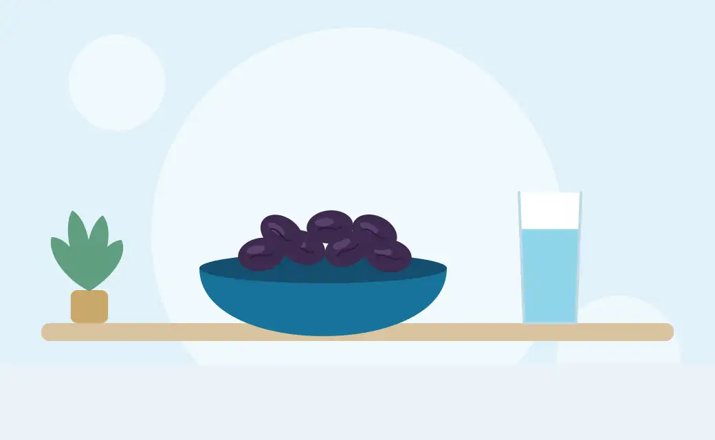 Illustration of a bowl of prunes next to a tall glass of water
